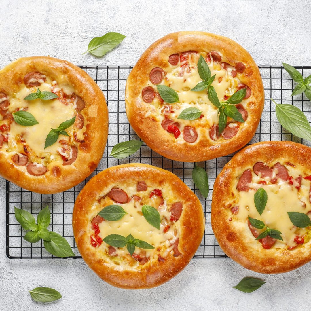 small homemade pizzas fresh with basil.